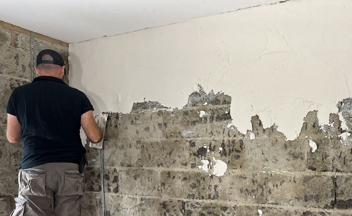 Supertherm Bonding coat applying the first thin bonding coat of the supertherm, picture shows the plasterer applying a thin coat of SuperTherm Insulating Plaster to the wall