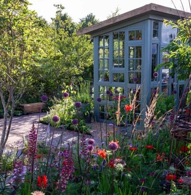 beautiful wooden conservatory made from reclaimed windows painted with graphenstone paint.